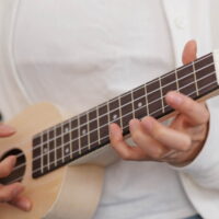 Online ukulele lernen Frau spielt zuhause